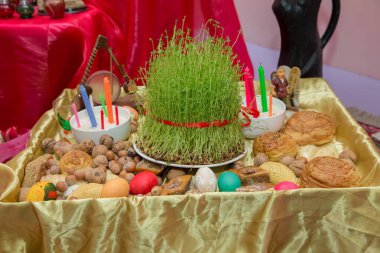 Semeni. Mum. Khoncha. Cehennemde, fındık. Geleneksel shekerbura, yumurta, mutaki, shirinchorek, kata ve pakhlava Novruz sembolü olarak beyaz arka planda Azerbaycan bayramında xoncha .