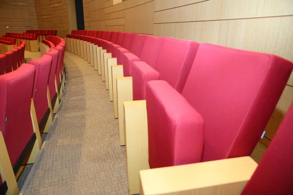 Assentos vermelhos no auditório silenciosamente e sem pessoas. Fileiras de assentos de teatro de veludo vermelho em um velho teatro de estilo Vaudeville. Assentos vermelhos vazios para cinema, teatro, conferência ou concerto — Fotografia de Stock