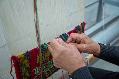 Yakın plan el yapımı halı dokuma ve üretimi. Kadın eli halı dokuyor. Kadın elleri halı dokuyor .