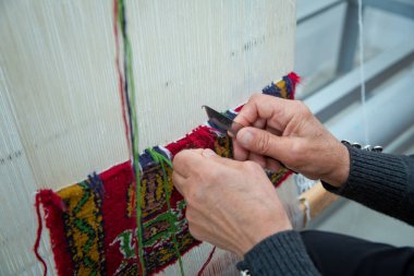 Yakın plan el yapımı halı dokuma ve üretimi. Kadın eli halı dokuyor. Kadın elleri halı dokuyor .
