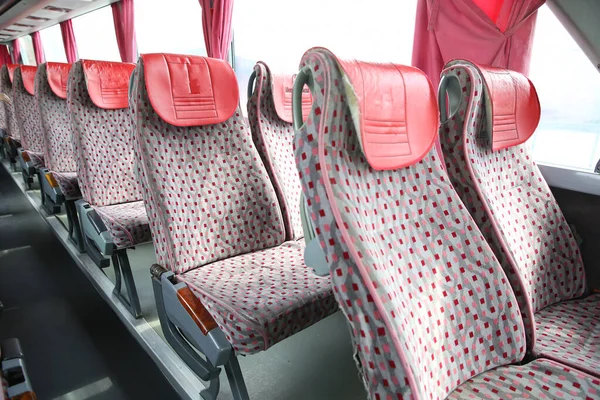 Wnętrza nowego nowoczesnego autobusu. pasy bezpieczeństwa autobusu. Siedzenie we wnętrzu autobusu, transport i komfortowe podróże. Otwarte podwójne wnętrze nowego nowoczesnego autobusu czerwone krzesła . — Zdjęcie stockowe