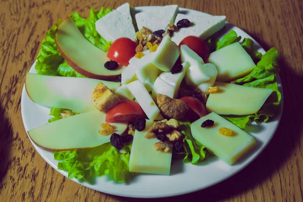 Vista superior. Placa de queso con diferentes tipos de queso con nueces de tomillo y tomates. Platos de queso servidos con moretones en una tabla de madera . —  Fotos de Stock