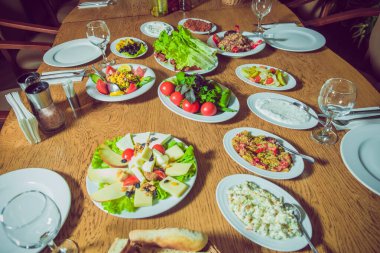 Domates, büyük boy salata. Peynir. Masa takımı ve salata. Partiden önce restoranda gümüş çatal bıçak ve cam kadehlerle servis. .