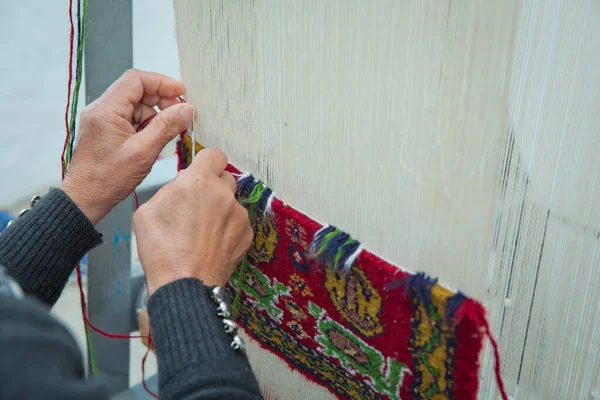 weaving and manufacturing of handmade carpets closeup. women's hands weave a carpet . Woman hands weaving carpet .