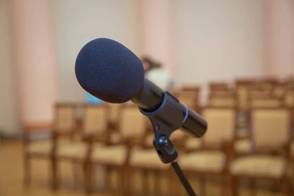 Дротовий мікрофон встановлений на передній частині конференц-залу крупним планом з розмитим фоном. Дротовий мікрофон крупним планом з копіювальним простором. Закриття мікрофона в концертному залі або конференц-залі  . — стокове фото