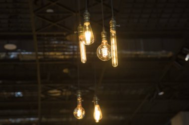 Parlak, geçmişe dönük, lüks lamba dekoru. Geceleri duvarda asılı duran klasik farklı retro ampuller. Tuğla duvara karşı dekoratif antika edison tarzı ampuller