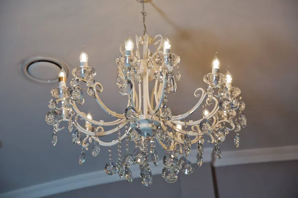 The lamp in the beautiful room .Brass chandelier with crystal. Chandelier ceiling lights
