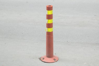 Gri asfalt üzerinde beyaz ve turuncu çizgileri olan trafik konisi, kopyala uzayı. Trafik güvenliği için trafik konisi. Trafik konisi. Garajdan alınmış..