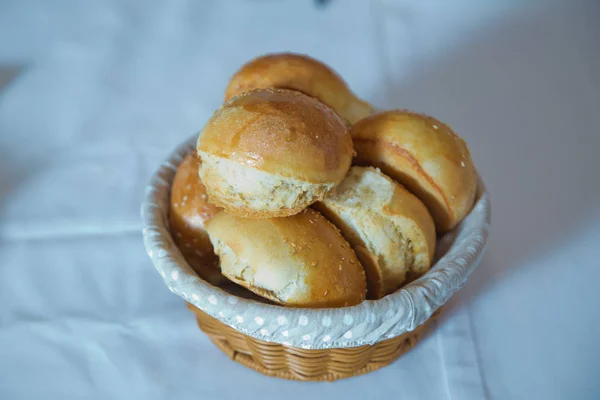 Koszyk z ciasta. Słodkie bułeczki z makiem w wiklinowym koszu, wokół chleba żytniego z nasionami sezamu . — Zdjęcie stockowe