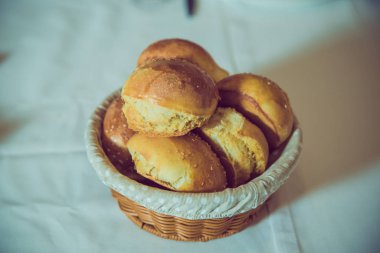 Hamurdan bir sepet. Hasır sepette haşhaş tohumlu tatlı çörekler, susamlı çavdar ekmeği. .