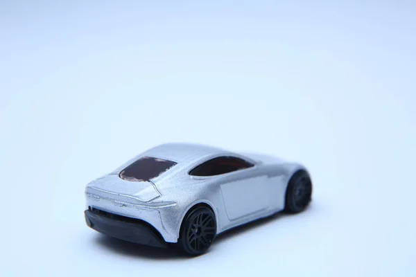 Игрушечная машина. Коллекционная игрушка модели серебристый спортивный автомобиль. Крупный план серебряного детского автомобиля на белом фоне  . — стоковое фото