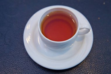 Ön manzara. Mavi arka planda çay fincanı. Kırpma yolu ile mavi bir arkaplanda izole beyaz cam bardak.