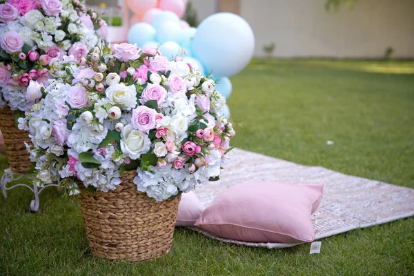 Pink and white Flowers Basket Green Grass Garden Summer . Summer Picnic on the lawn. blue balloon . Closeup of picnic basket with white flowers on the grass .