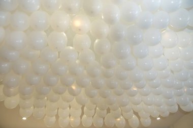 Düğün ya da çocukların doğum günü partisi dekorasyonu. Helyum balonları. Beyaz balonlar parti için odadaki beyaz tavanda yüzüyor..