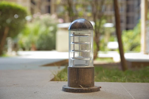 Lamp set on a wood on a high ground . small lantern in a garden on the ground . Lighting ground lamp street mounted on a green lawn in a park . — Stock Photo, Image