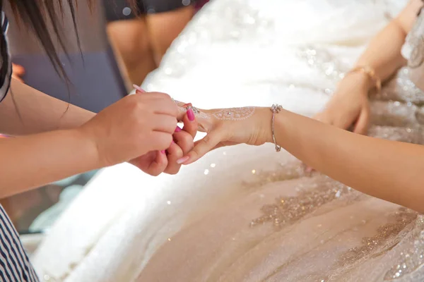 Noiva colocando jóias, foco em pulseira. Close up do noivo dando sua pulseira de noiva como símbolo de seu amor no dia do casamento. dama de honra ajuda a colocar uma pulseira em seu braço para a noiva . — Fotografia de Stock