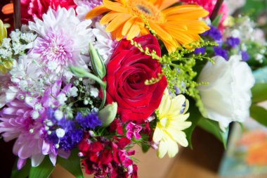 Kırmızı çiçek resmi buketin içinde. Çiçeğin taç yaprağı. Taze kırmızı, beyaz, turuncu güller. Bir buket çok renkli gül. .