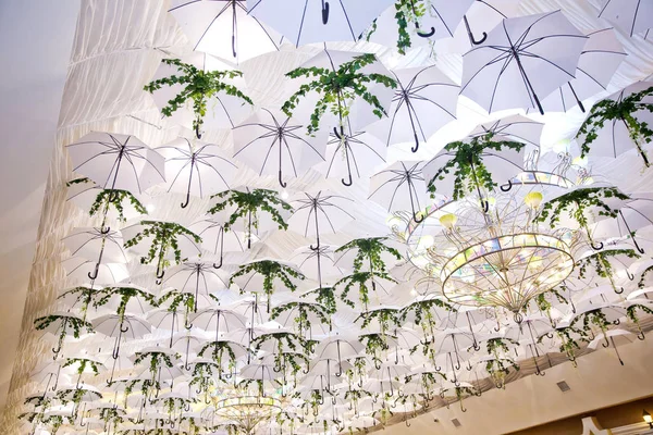 Witte en groene unbrellas op het centrum: Hang aan het plafond, in het restaurant. Witte unbrellas achtergrond. Mooie dakdecoratie. — Stockfoto