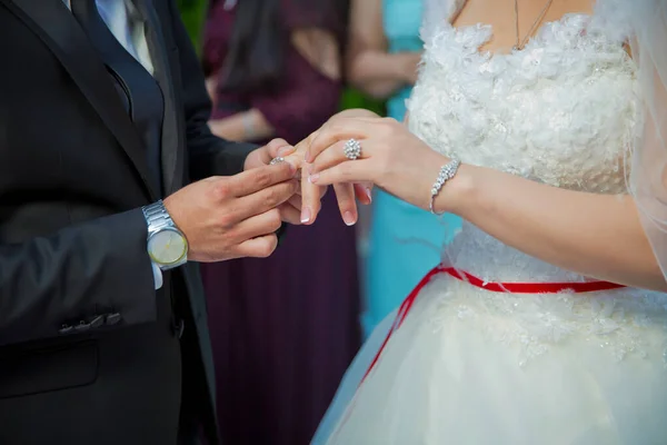 Novio pone anillo de bodas en la mano de la novia en la iglesia .Man pone un anillo de bodas en la mano de una novia, foto de cerca. Pone un anillo en la mano de la novia  . — Foto de Stock