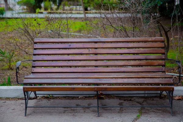 Blanco Oude bank in een schaduwrijk gedeelte van de tuin of het park, buiten. Schaduwrijke houten parkbank omgeven door groen. Leeg Park houten bank Close-up uitzicht. Hout buitenmateriaal. Gegevens over houtmateriaal. — Stockfoto