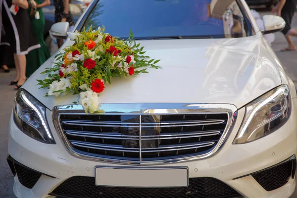 Çiçeklerle süslenmiş lüks bir düğün arabası. Sadece evlilik tabelası ve konserve kutuları. Düğün arabasında düğün süsü. — Stok fotoğraf