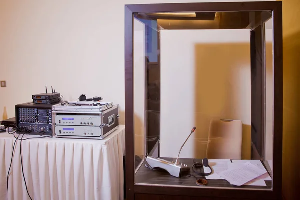 Kablosuz konferans mikrofonları ve toplantı odasındaki defter. Çevirmenler kabinine. yorumlama - Eş zamanlı tercüman kabininde mikrofon ve santral .