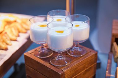 - Otelde kahvaltı. Tahta bir masada dört bardak süt..