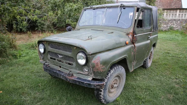 Soviet UAZ SUV on a city street .Glass headlight of an old retro russian truck SUV all-terrain khaki colour . Ahead of the UAZ — ストック写真