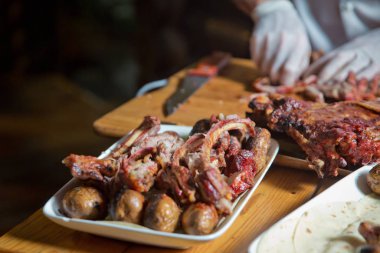 Barbekü kuzu etinden ya da koyun etinden yapılır ve slasher tarafından işlenir. Antrikot ve patates kebabı beyaz bir tabakta. Açık ateşte kızartılmış et, özel bir şekilde pişirilmiş..