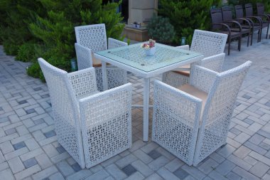 Dışarıda güneşli bir restoranın sandalyeleri ve masaları. Bahçe terası beyaz masası güzel bir kahvaltı için hazırlandı. Bahçede beyaz plastik masa ve sandalyeler. Restoranda boş beyaz masalar.