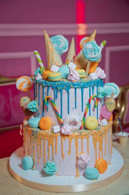 Pasta ve pasta için süsleme. Renkli kek, waffle külahında dondurma için, beyaz ahşap masa üzerine şekerleme serpiştirilmiş. Renkli küçük tatlı toplu mavi pasta .