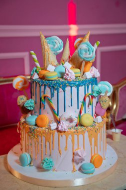 Renkli küçük tatlı toplu mavi pasta. Pasta ve pasta için süsleme. Dondurma için waffle külahında renkli kek, beyaz ahşap masa üzerine şekerleme serpiştirilmiş..