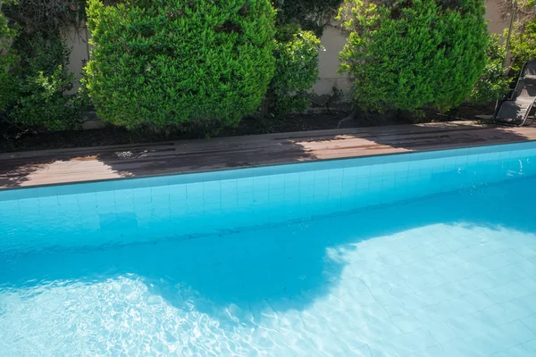 Swimmingpool design på modernt residens. Backyard pool med dykbräda. Vacker uppfriskande klarblått vatten i utomhuspoolen i trädgården. Trädgårdshus vid poolen. — Stockfoto