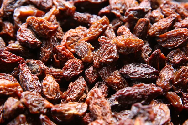 Black raisins in the wooden bowl. Sweet dry raisins close-up shot for background . Many Raisins for background grape raisin texture . — Stock Photo, Image