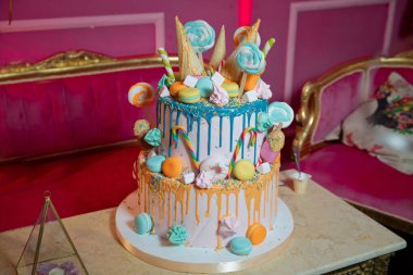 Pasta ve pasta için süsleme. Renkli kek, waffle külahında dondurma için, beyaz ahşap masa üzerine şekerleme serpiştirilmiş. Renkli küçük tatlı toplu mavi pasta .