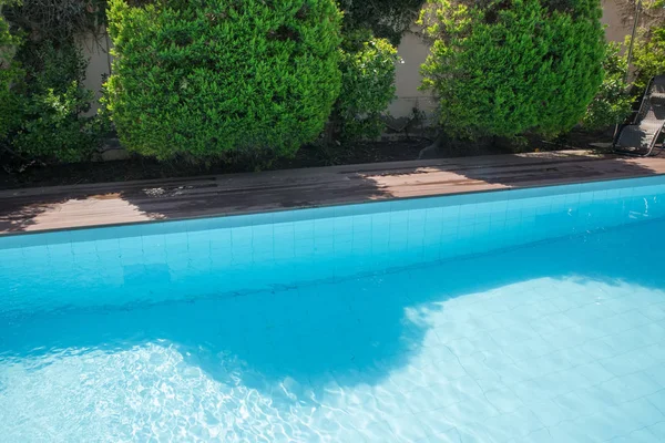 Diseño de la piscina en la residencia moderna. Piscina del patio trasero con trampolín. Hermosa refrescante agua azul clara en la piscina al aire libre en el jardín. Casa de jardín junto a la piscina . —  Fotos de Stock