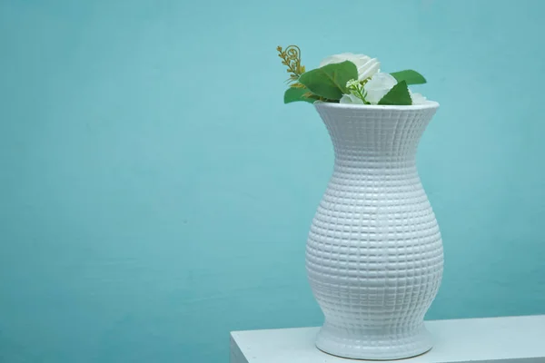 风格的照片。 山谷中的百合花照片。美丽的白花在白桌上的壶中。 绿色背景上的瓶中白花. — 图库照片