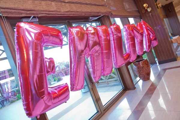 Шарики гелия образуют слово розового цвета Эмилия. Шаблон украшения вечеринки Эмилии. Слово "Эмилия" из розовых надувных шариков. . — стоковое фото