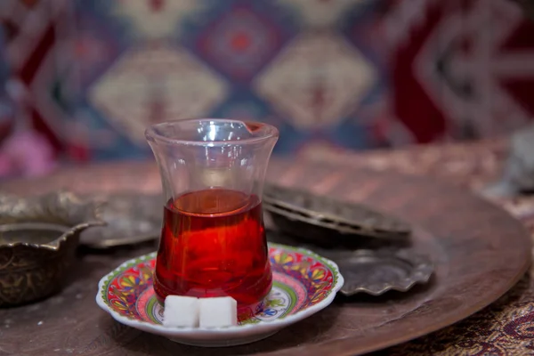 Té en Azerbaiyán tradicional armudu en forma de pera de vidrio. Azerbaiyán té negro .white terrones de azúcar. Té turco negro en vidrio en forma de pera, té aromático tradicional azerbaiyano en taza de armudu  . — Foto de Stock