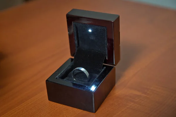 Paar Eheringe in einer Geschenkbox isoliert auf Holzgrund. Ehering in schwarzer Schachtel Holzhintergrund . — Stockfoto