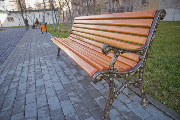 Träets yttre material. Trädetaljer. Tomma Gamla bänk i ett skuggigt område i trädgården eller parken, utomhus. Skuggade trä park bänk omgiven av grönska. Tomt Park träbänk Närbild. — Stockfoto