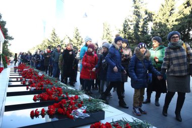 20 Ocak trajedisinin yıldönümünde Sovyet Ordusu 'nun 1990 yılında Bakü' ye saldırıp 137 kişinin öldüğü, 744 kişinin yaralandığı Şehitler Sokağı 'nı ziyaret eden insanlar görülüyor.