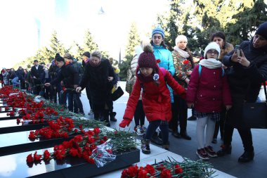 20 Ocak trajedisinin yıldönümünde Sovyet Ordusu 'nun 1990 yılında Bakü' ye saldırıp 137 kişinin öldüğü, 744 kişinin yaralandığı Şehitler Sokağı 'nı ziyaret eden insanlar görülüyor.