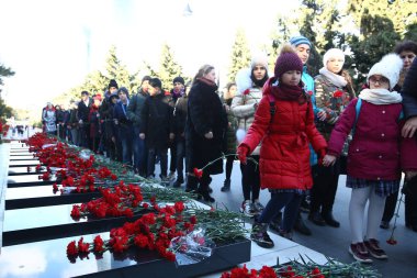 20 Ocak trajedisinin yıldönümünde Sovyet Ordusu 'nun 1990 yılında Bakü' ye saldırıp 137 kişinin öldüğü, 744 kişinin yaralandığı Şehitler Sokağı 'nı ziyaret eden insanlar görülüyor.