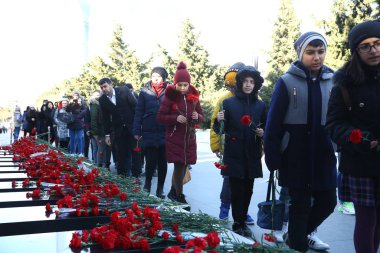 20 Ocak trajedisinin yıldönümünde Sovyet Ordusu 'nun 1990 yılında Bakü' ye saldırıp 137 kişinin öldüğü, 744 kişinin yaralandığı Şehitler Sokağı 'nı ziyaret eden insanlar görülüyor.