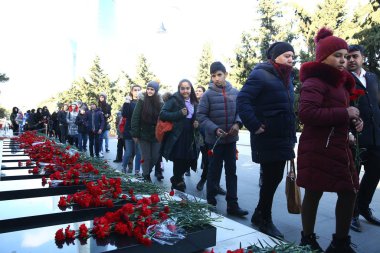 20 Ocak trajedisinin yıldönümünde Sovyet Ordusu 'nun 1990 yılında Bakü' ye saldırıp 137 kişinin öldüğü, 744 kişinin yaralandığı Şehitler Sokağı 'nı ziyaret eden insanlar görülüyor.