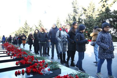 20 Ocak trajedisinin yıldönümünde Sovyet Ordusu 'nun 1990 yılında Bakü' ye saldırıp 137 kişinin öldüğü, 744 kişinin yaralandığı Şehitler Sokağı 'nı ziyaret eden insanlar görülüyor.