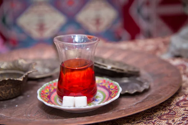 Té en Azerbaiyán tradicional armudu en forma de pera de vidrio. Azerbaiyán té negro .white terrones de azúcar. Té turco negro en vidrio en forma de pera, té aromático tradicional azerbaiyano en taza de armudu  . — Foto de Stock