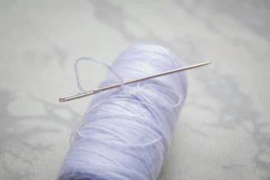 White bobbin with needle isolated on white .Close up sewing thread with an embroidery needle. Crafts and DIY concepts . Needle on white thread white background.