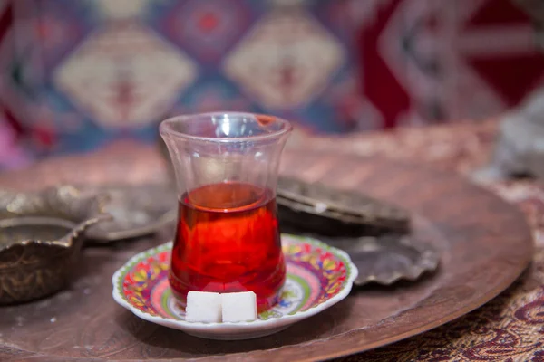 Té en Azerbaiyán tradicional armudu en forma de pera de vidrio. Azerbaiyán té negro .white terrones de azúcar. Té turco negro en vidrio en forma de pera, té aromático tradicional azerbaiyano en taza de armudu  . — Foto de Stock